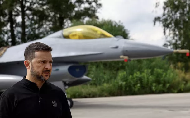 O presidente da Ucrânia, Volodymyr Zelensky, fala à mídia na frente de um avião de combate F-16 