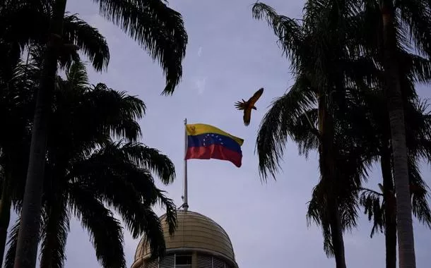 Uma arara voa perto de bandeira venezuelana no Palácio Federal Legislativo, em Caracas, Venezuela 
16/04/2024