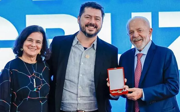 O presidente Lula e a ministra Nísia Trindade posam para foto com o biólogo Atila Iamarino e sua medalha Oswaldo Cruz