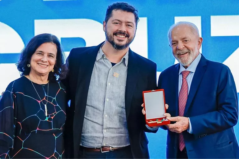O presidente Lula e a ministra Nísia Trindade posam para foto com o biólogo Atila Iamarino e sua medalha Oswaldo Cruz