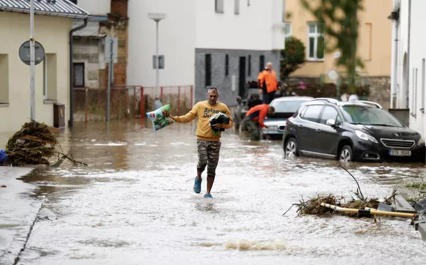 Um homem atravessa a enchente em uma área inundada, após fortes chuvas em Jesenik, República Tcheca, 15 de setembro de 2024