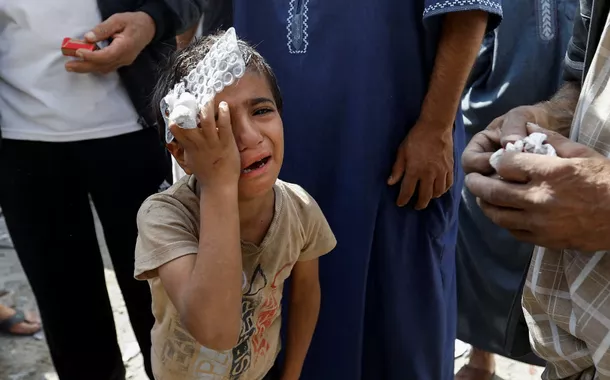 Um menino palestino reage no local dos ataques israelenses a casas