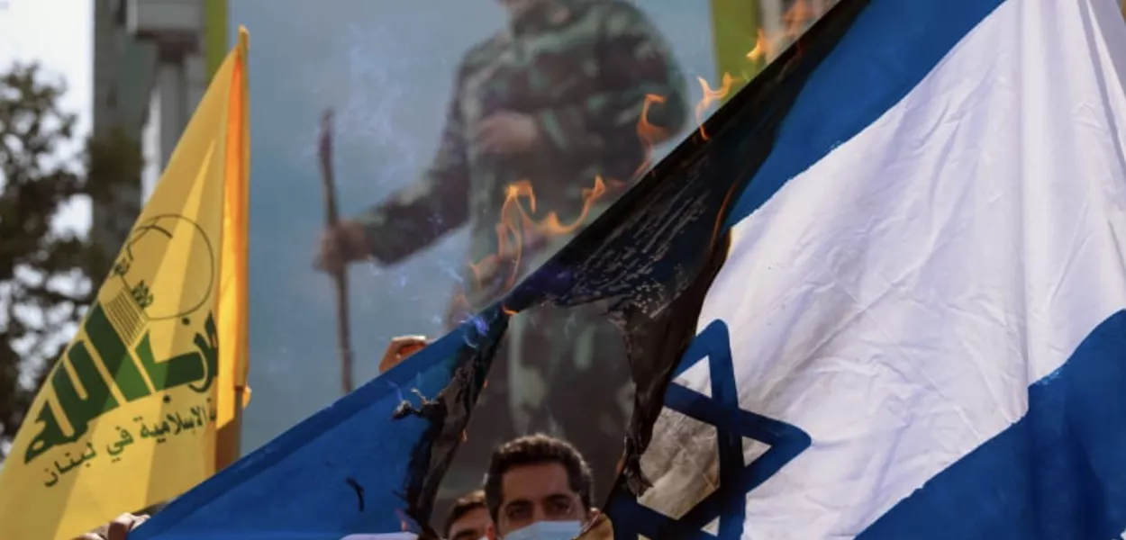 Iranianos queimam uma bandeira israelense durante um comício no Dia Anual de Quds, em Teerã, Irã, em 7 de maio de 2021