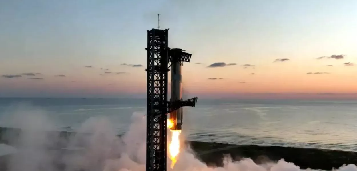 O Super Heavy retornando ao local de lançamento para ser capturado por sua torre de lançamento em seu vôo de 13 de outubro