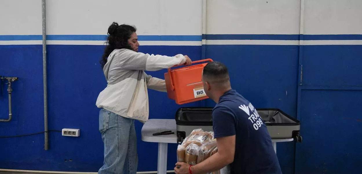 Funcionária eleitoral prepara material de votação para distribuição em Montevidéu, 25/10/2024