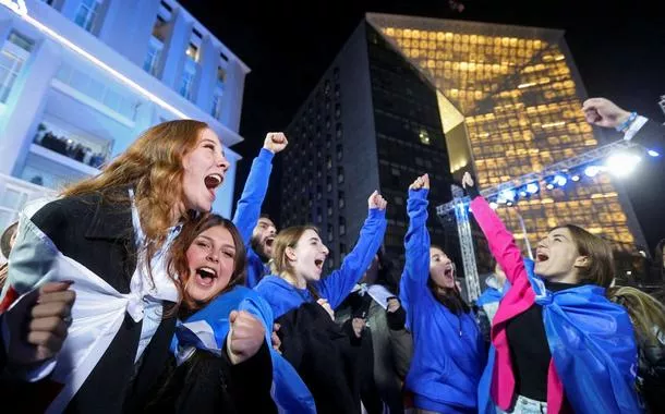 Simpatizantes do partido Sonho Georgiano comemoram anúncio de pesquisa de boca de urna em Tbilisi, Geórgia, 26/10/2024 