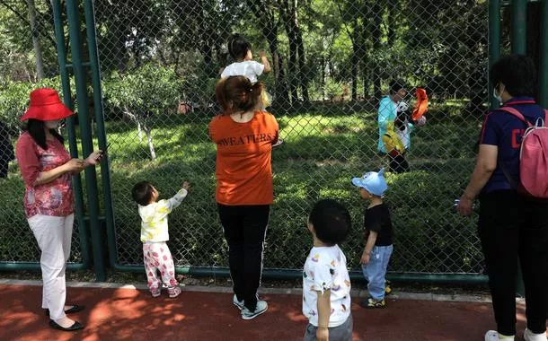 Crianças brincam com adultos em parque de Pequim, na China