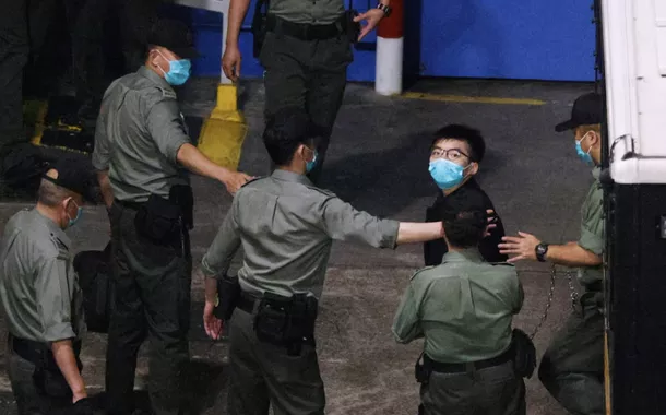 O ativista Joshua Wong observa ao chegar ao Centro de Recepção Lai Chi Kok depois de permanecer sob custódia por causa da acusação de lei de segurança nacional, em Hong Kong, China, 2 de março de 2021