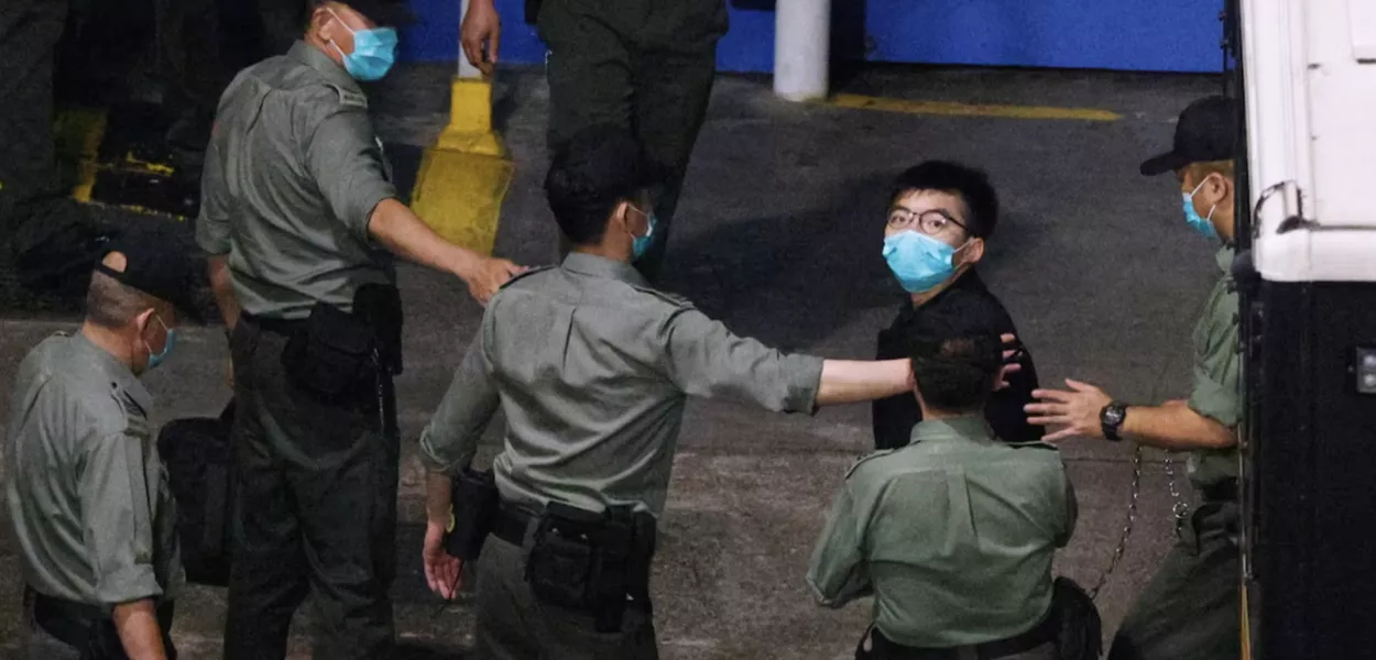 O ativista Joshua Wong observa ao chegar ao Centro de Recepção Lai Chi Kok depois de permanecer sob custódia por causa da acusação de lei de segurança nacional, em Hong Kong, China, 2 de março de 2021