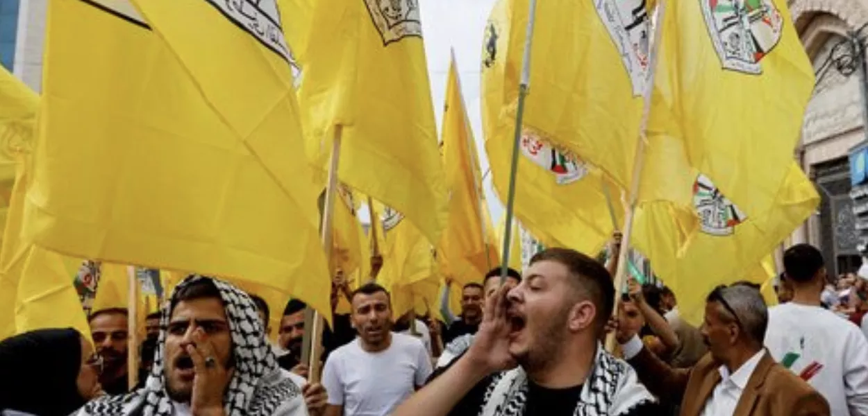 Pessoas seguram bandeiras do Fatah durante um protesto em apoio ao povo de Gaza, em Hebron, na Cisjordânia ocupada por Israel, 27 de outubro de 2023