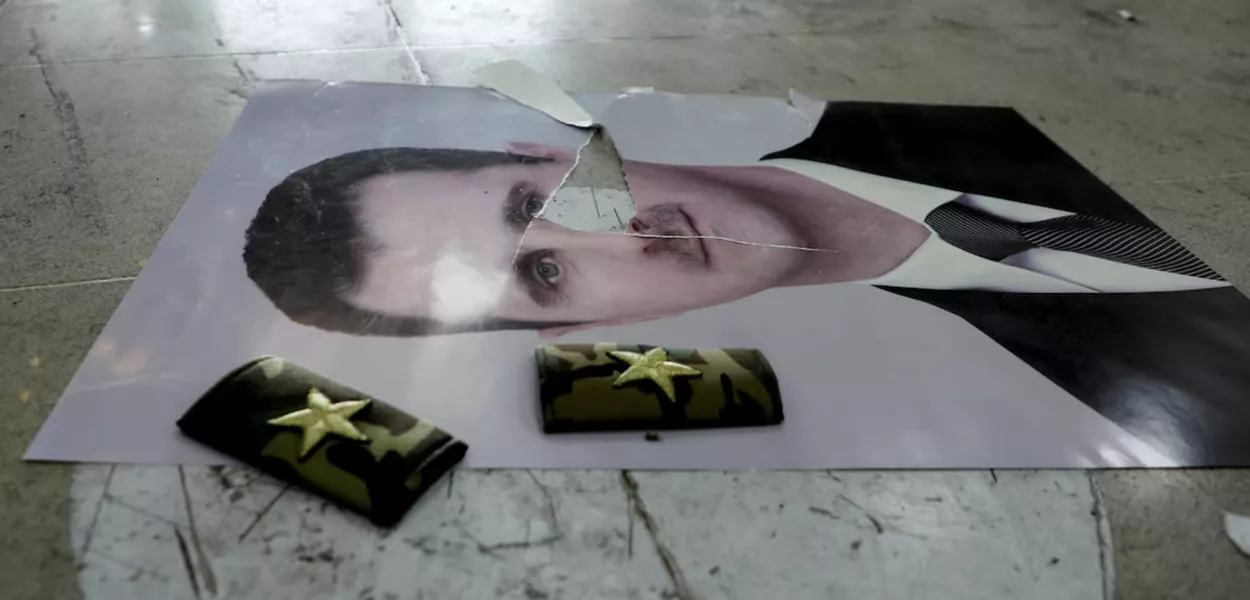 Uma foto danificada de Bashar al-Assad da Síria está no chão dentro do aeroporto internacional de Qamishli, depois que grupos armados sírios anunciaram que haviam derrubado Bashar al-Assad da Síria, em Qamishli, Síria, 9 de dezembro