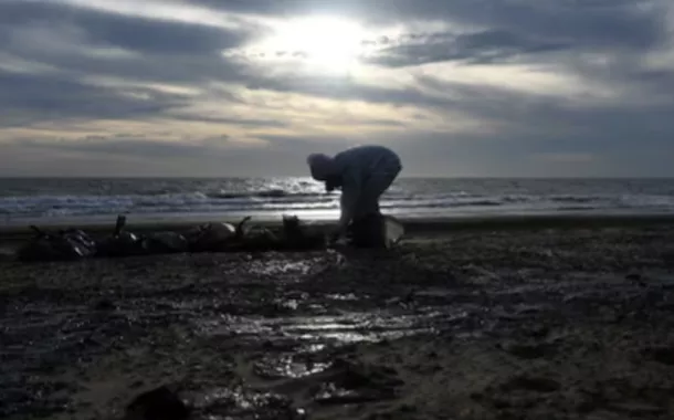 Um voluntário trabalha para limpar o óleo derramado na costa após um incidente envolvendo dois navios-tanque danificados em uma tempestade no Estreito de Kerch, no assentamento de Blagoveshchenskaya, perto do resort de Anapa, no Mar Negro, na região de Krasnodar, Rússia, 21 de dezembro de 2024