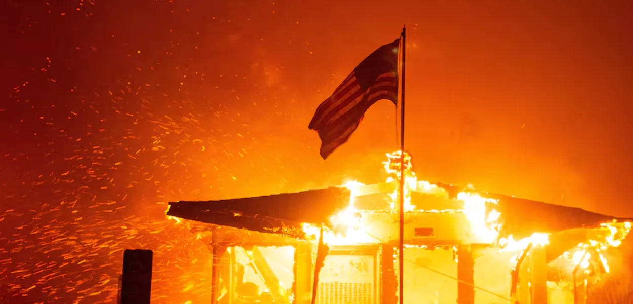 Bandeira dos EUA tremula enquanto o fogo envolve casa em Los Angeles, Califórnia