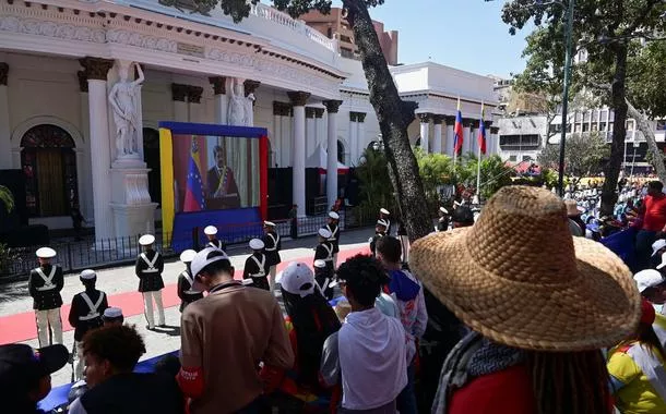 Pessoas acompanham telão em Caracas enquanto presidente da Venezuela, Nicolás Maduro, presta juramento para um terceiro mandato de seis anos - 10/01/2025