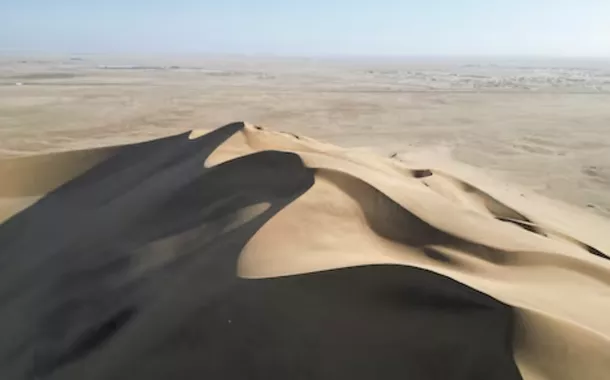 Uma vista de drone da Duna 7 e um deserto ao fundo em Walvis Bay, Namíbia, 26 de fevereiro de 2024