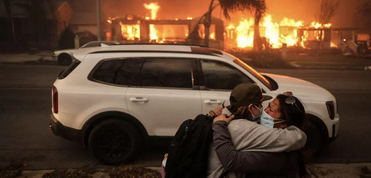 Pessoas se abraçam em meio aos incêndios florestais devastadores na região de Los Angeles, Califórnia, EUA, 8 de janeiro de 2025