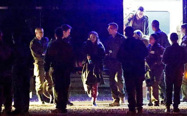 Pessoas caminham em direção a helicópteros militares israelenses enquanto Romi Gonen, Doron Steinbrecher e Emily Damari, três reféns que foram mantidas em Gaza desde o ataque mortal de 7 de outubro de 2023, retornam a Israel como parte de um acordo de cessar-fogo em Gaza entre o Hamas e Israel, na fronteira de Israel com Gaza, no sul de Israel, em 19 de janeiro de 2025. 