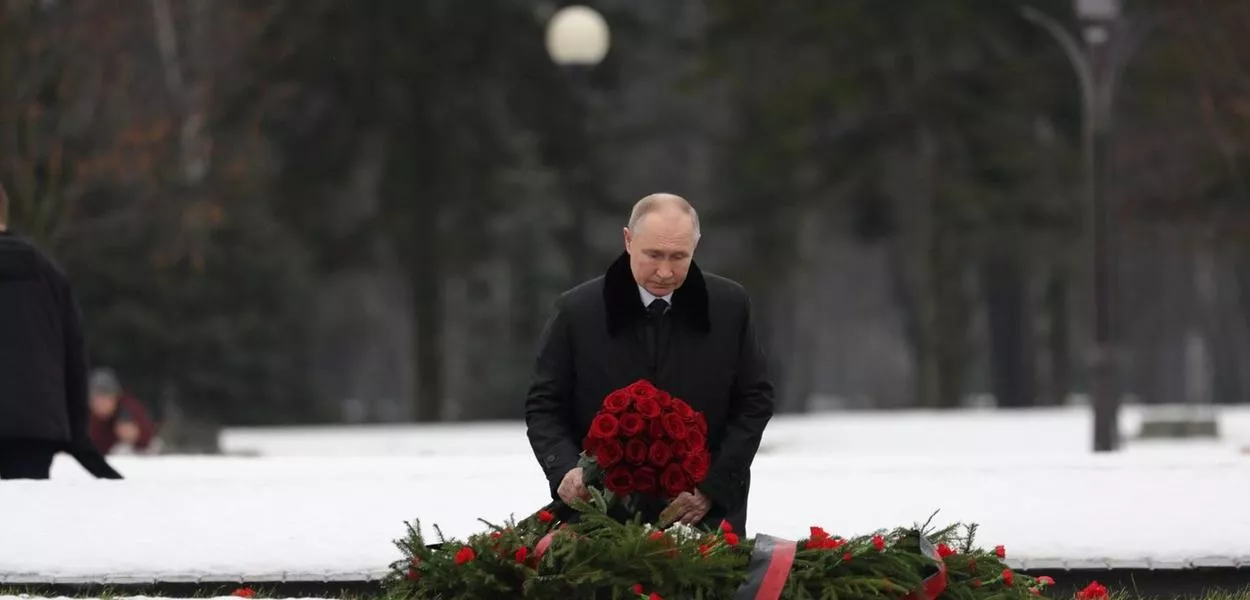 Enquanto caminhava em direção ao monumento à Pátria no Cemitério Memorial Piskaryovskoye, Vladimir Putin deposita flores em uma vala comum, durante os eventos comemorativos que marcam o 81º aniversário do rompimento do cerco de Leningrado
