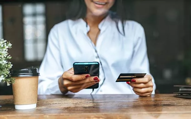Mulher usa celular para comprar produtos