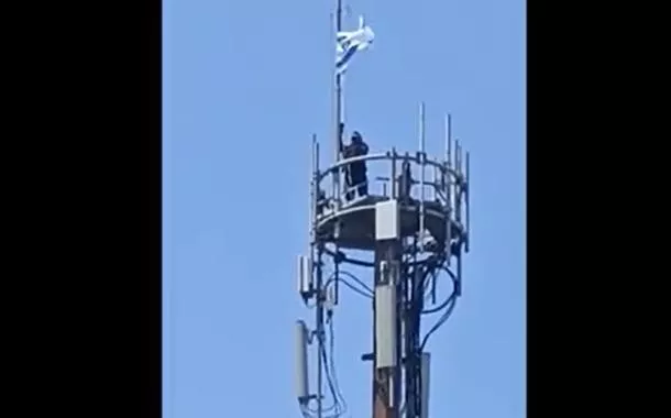 Agente retira bandeira usada por criminosos no Rio