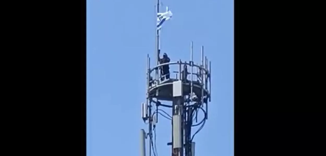 Agente retira bandeira usada por criminosos no Rio