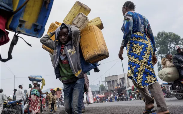 Civis deslocados internamente dos campos de Munigi e Kibati transportam os seus pertences enquanto fogem na sequência da luta entre os rebeldes M23 e as Forças Armadas da República Democrática do Congo (FARDC), em Goma, leste da República Democrática do Congo