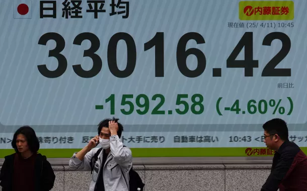 Pessoas passam por uma tela eletrônica exibindo a média das ações Nikkei do Japão do lado de fora de uma corretora em Tóquio, Japão, em 11 de abril de 2025. REUTERS/Kim Kyung-Hoon