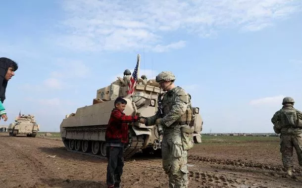 Soldado de coalizão liderada pelos EUA dá a mão para garoto em Qamishli, Síria
08/02/2024. 