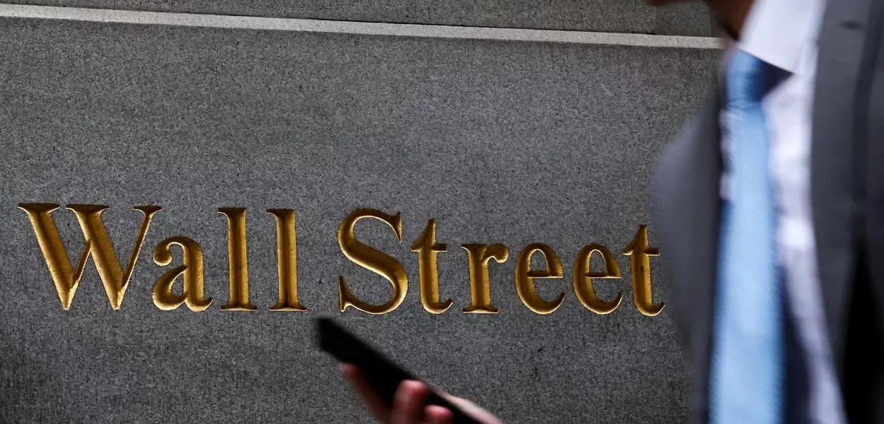 Homem caminha na Wall St. do lado de fora da Bolsa de Nova York - 07/04/2025