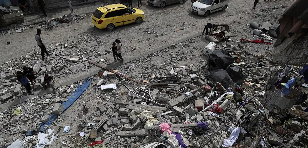 Palestinos inspecionam o local de um ataque israelense a uma casa na Cidade de Gaza
