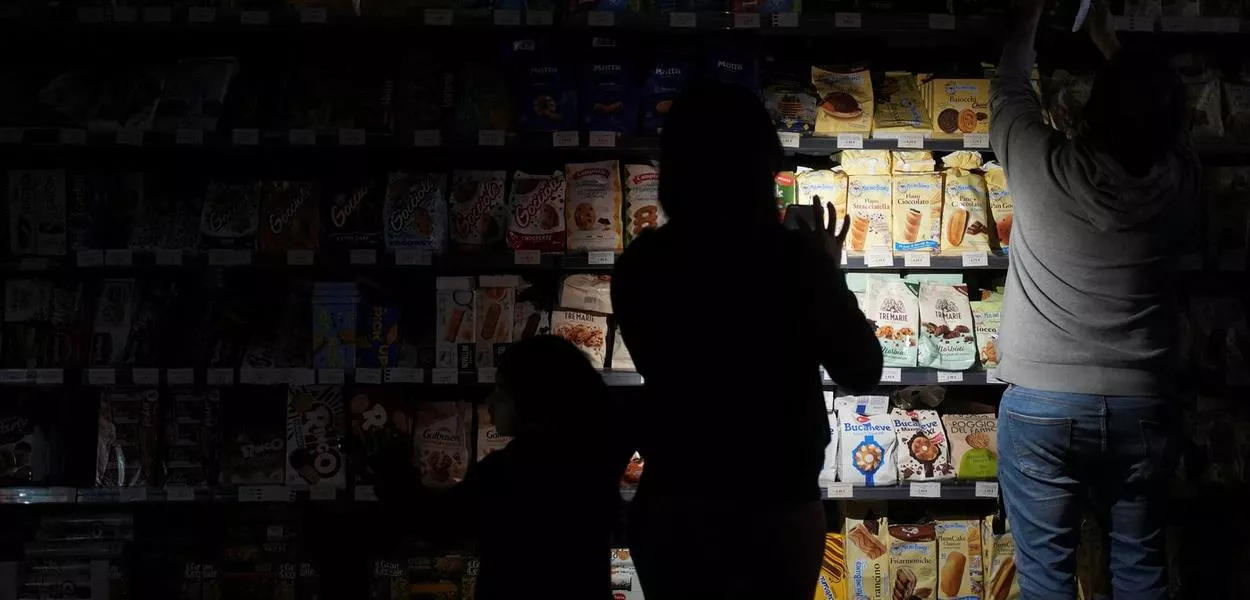 Pessoas usam celulares e lanternas para comprar mantimentos dentro do supermercado durante o apagão em Barcelona
28/04/2025