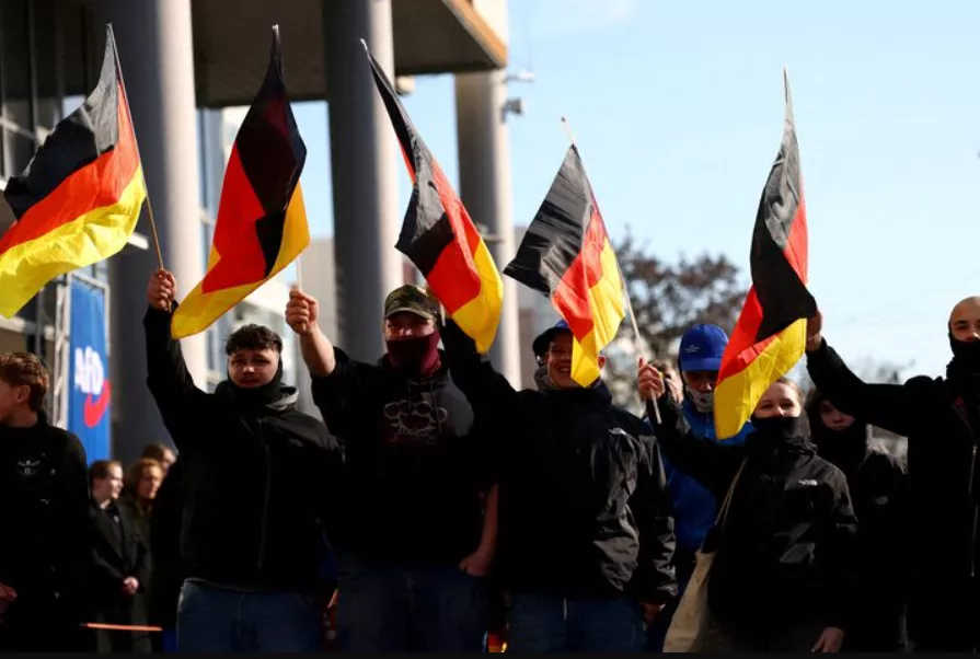 Apoiadores do partido Alternativa para a Alemanha (AfD) agitam bandeiras enquanto participam de um comício de campanha da sigla em Hohenschoenhausen, Berlim, Alemanha, em 22 de fevereiro de 2025
