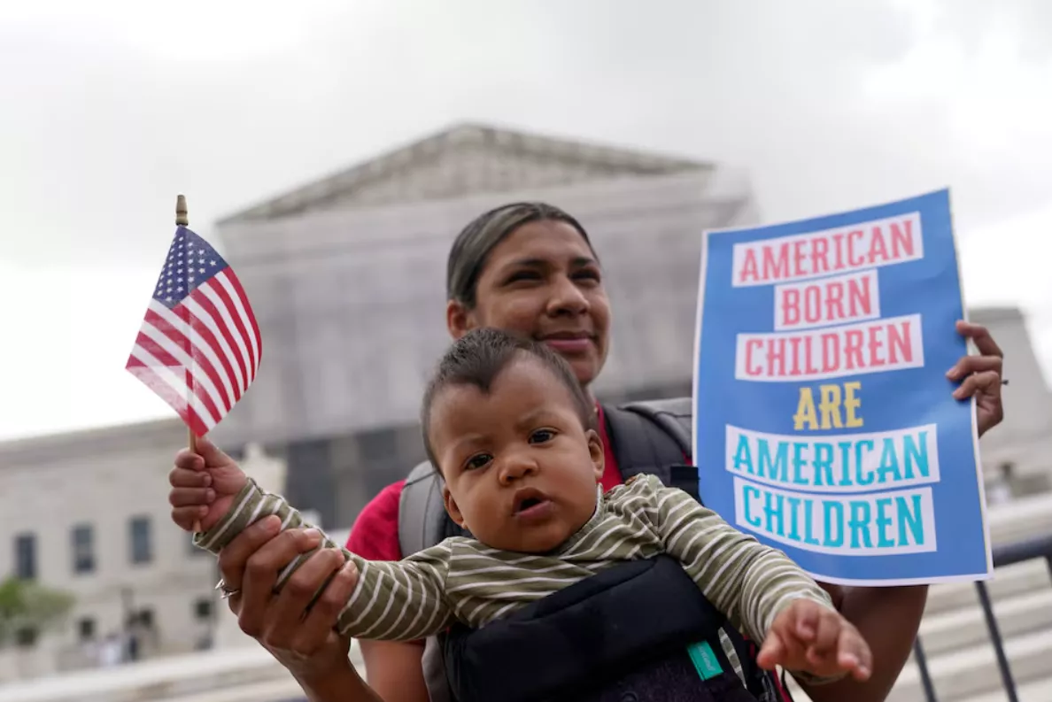 Olga Urbina carrega o bebê Ares Webster enquanto manifestantes se reúnem no dia em que os juízes da Suprema Corte ouvem os argumentos orais sobre a tentativa do presidente dos EUA, Donald Trump, de aplicar amplamente sua ordem executiva para restringir a cidadania automática por direito de nascimento, durante um protesto em frente à Suprema Corte dos EUA em Washington, DC, EUA, 15 de maio de 2025