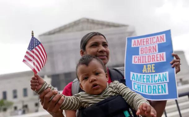 Olga Urbina carrega o bebê Ares Webster enquanto manifestantes se reúnem no dia em que os juízes da Suprema Corte ouvem os argumentos orais sobre a tentativa do presidente dos EUA, Donald Trump, de aplicar amplamente sua ordem executiva para restringir a cidadania automática por direito de nascimento, durante um protesto em frente à Suprema Corte dos EUA em Washington, DC, EUA, 15 de maio de 2025