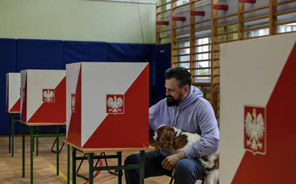 Um homem se prepara para votar durante o primeiro turno das eleições presidenciais da Polônia em uma seção eleitoral em Varsóvia, Polônia, em 18 de maio de 2025