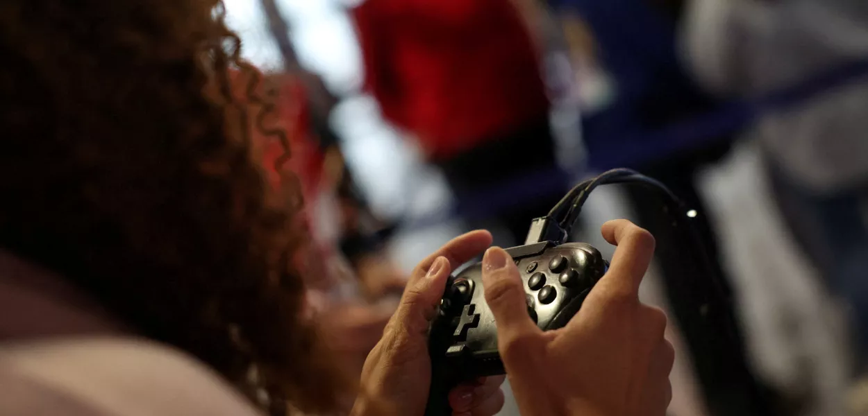 Um participante usa um console de videogame Nintendo Switch enquanto joga videogame na Paris Games Week (PGW), uma feira de videogames, em 5 de novembro de 2023