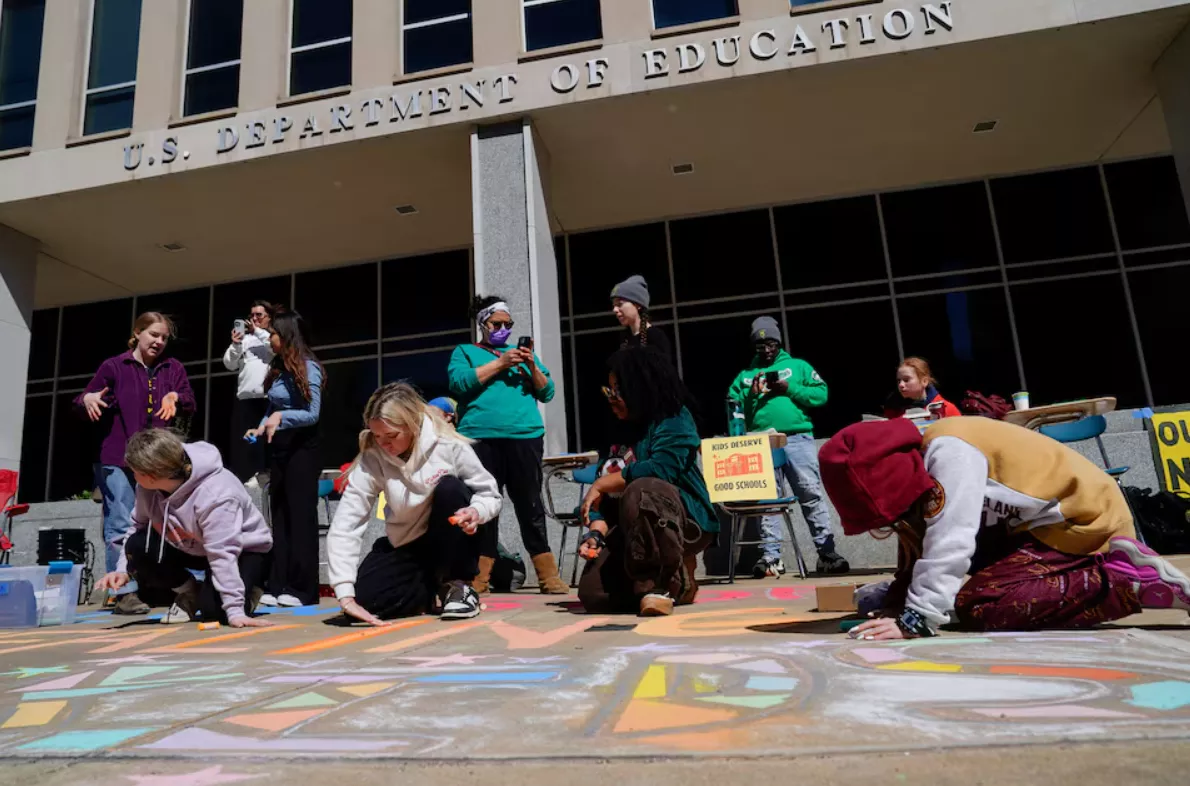 Manifestantes participam de um protesto do movimento Defend Our Schools contra a ordem executiva do presidente dos EUA, Donald Trump, de fechar o Departamento de Educação dos EUA em frente ao seu prédio em Washington, DC, EUA, em 21 de março de 2025