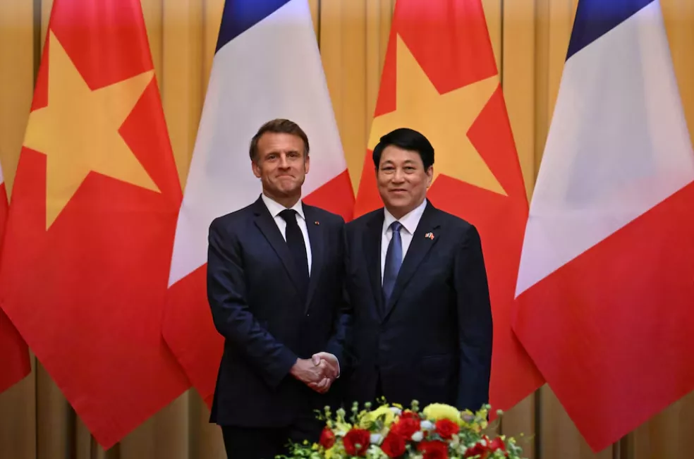 O presidente francês Emmanuel Macron e o presidente do Vietnã Luong Cuong apertam as mãos durante uma reunião no Palácio Presidencial em Hanói em 26 de maio de 2025