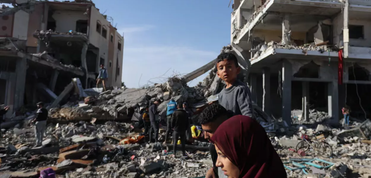 Palestinos deslocados retornam para suas casas enquanto caminham perto de casas destruídas em um ataque israelense durante o conflito, em meio à trégua temporária entre o Hamas e Israel, em Khan Younis, no sul da Faixa de Gaza, em 24 de novembro de 2023