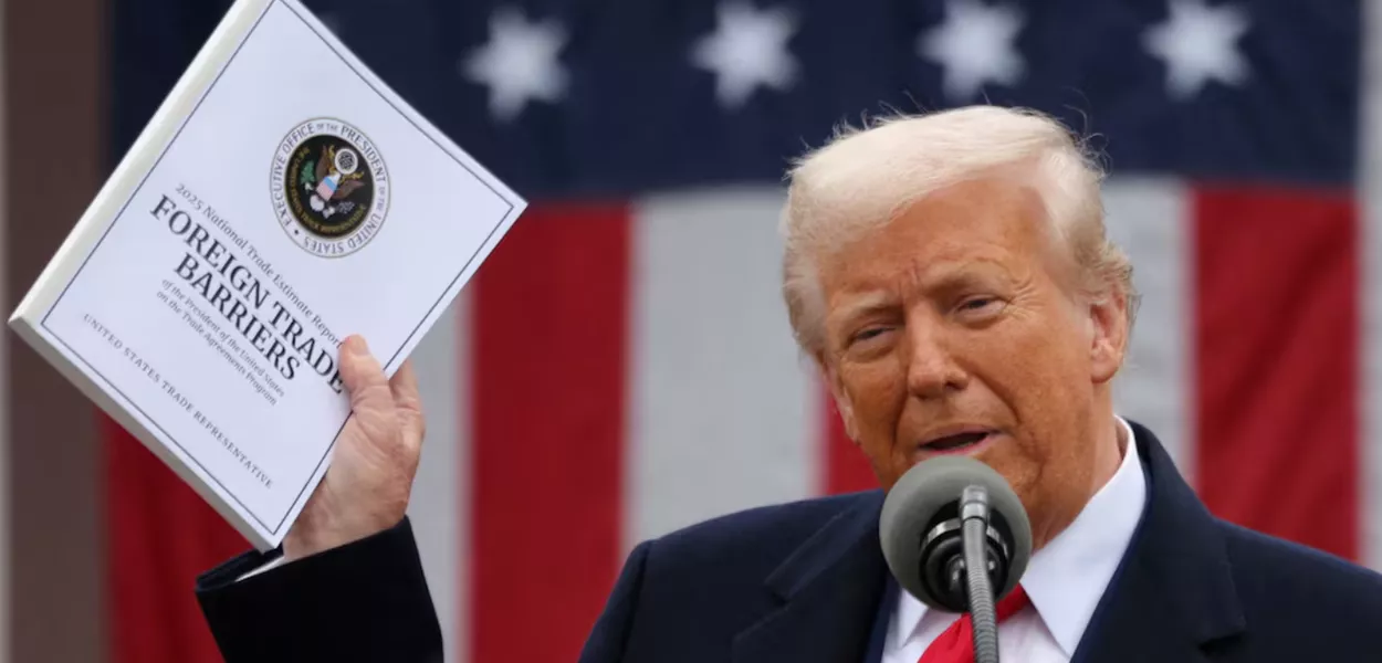 O presidente dos EUA, Donald Trump, segura um documento sobre "Barreiras ao Comércio Exterior" enquanto faz comentários sobre tarifas no Rose Garden, na Casa Branca, em Washington, DC, EUA, em 2 de abril de 2025
