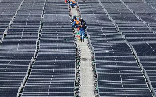 Trabalhadores em usina de energia solar flutuante na represa Billings

