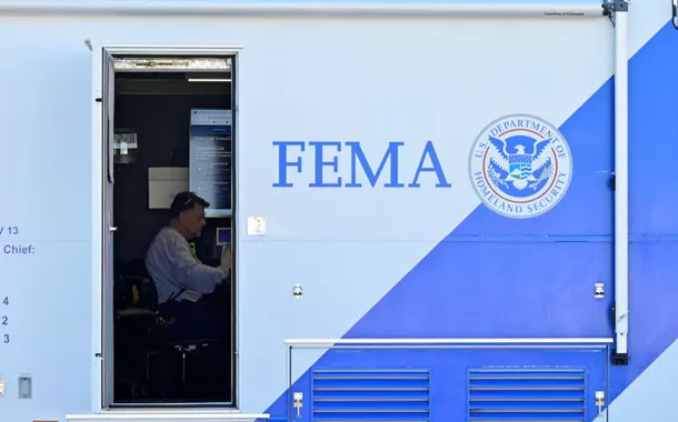 Pessoa sentada em uma mesa dentro de um centro de comando móvel da FEMA após tornados terem atingido vários estados dos EUA no centro de Dawson Springs, Kentucky, EUA, em 14 de dezembro de 2021
