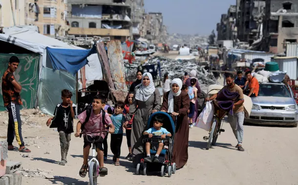 Palestinos carregam seus pertences enquanto fogem de suas casas após o exército israelense emitir ordens de evacuação, em Khan Younis, no sul da Faixa de Gaza, em 3 de junho de 2025