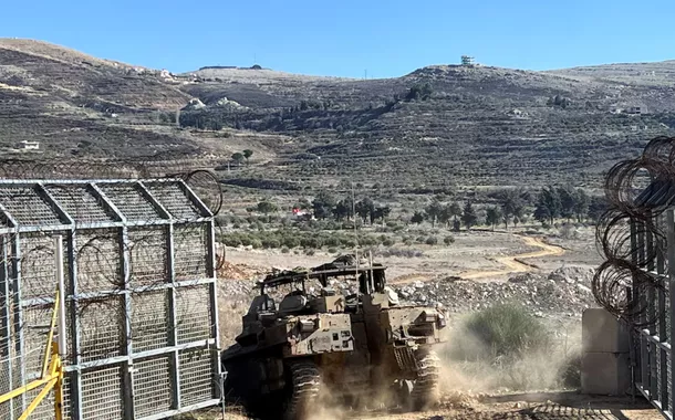 Um veículo blindado de transporte de pessoal israelense (APC) entra na Síria na linha de cessar-fogo com a Síria e as Colinas de Golã ocupadas por Israel, visto das Colinas de Golã, em 13 de dezembro de 2024