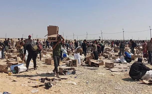 Palestinos coletam restos de suprimentos de ajuda da Fundação Humanitária de Gaza, apoiada pelos EUA, em Rafah
