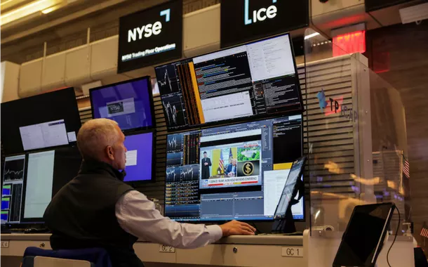 Uma tela mostra o CEO da Tesla, Elon Musk, e o presidente dos EUA, Donald Trump, enquanto um operador de opções futuras trabalha no pregão da Bolsa de Valores de Nova York (NYSE), na cidade de Nova York, EUA, em 30 de maio de 2025