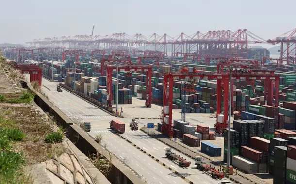 Guindastes de pórtico perto de contêineres no Porto de Yangshan, nos arredores de Xangai, China, em 15 de abril de 2025