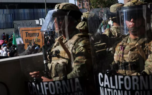 Membros da Guarda Nacional da Califórnia formam uma fila, bloqueando a entrada do Edifício Federal, em Los Angeles, em 9 de junho