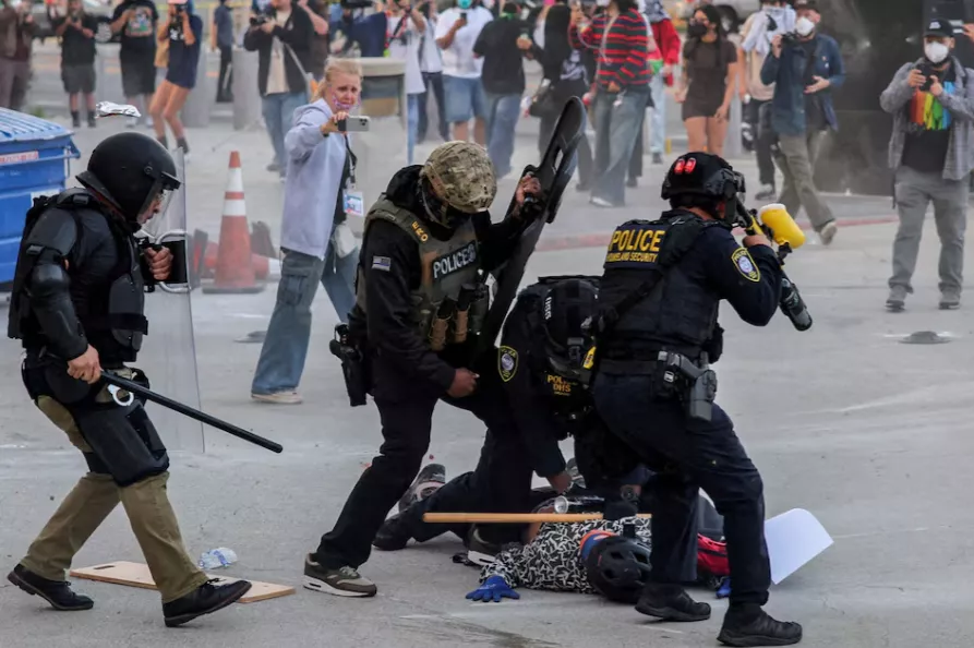 Policiais agridem um manifestante que bloqueava a entrada da garagem do Edifício Federal de Los Angeles após múltiplas detenções pelo Serviço de Imigração e Alfândega (ICE), no centro de Los Angeles, Califórnia, EUA, em 6 de junho de 2025