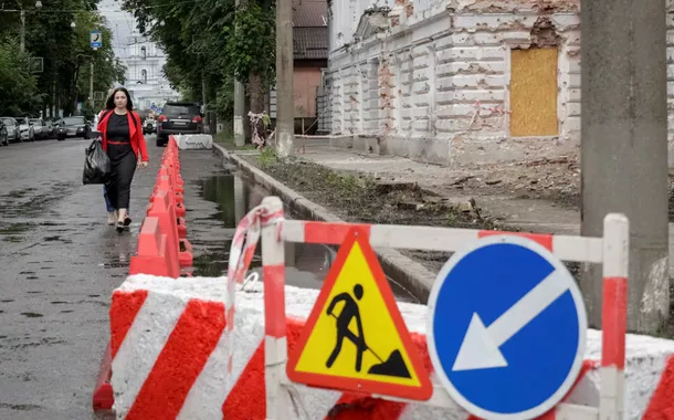 Um morador caminha por uma rua perto de um prédio danificado por ataques de mísseis russos, em meio ao ataque da Rússia à Ucrânia, em Sumy, Ucrânia, em 13 de junho de 2025